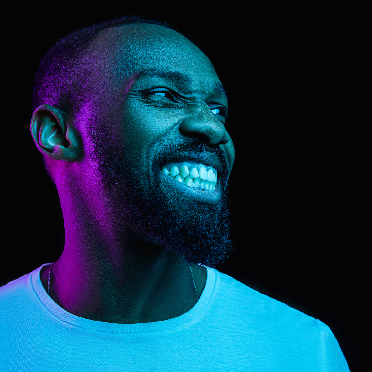 man smiling in blue pink light