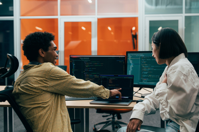 man and woman pointing to code on laptop artificial inteliigence consulting